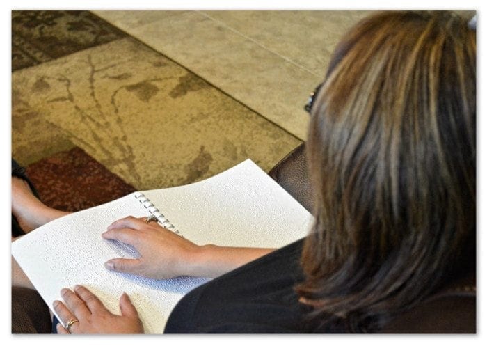 person sitting and reading braille