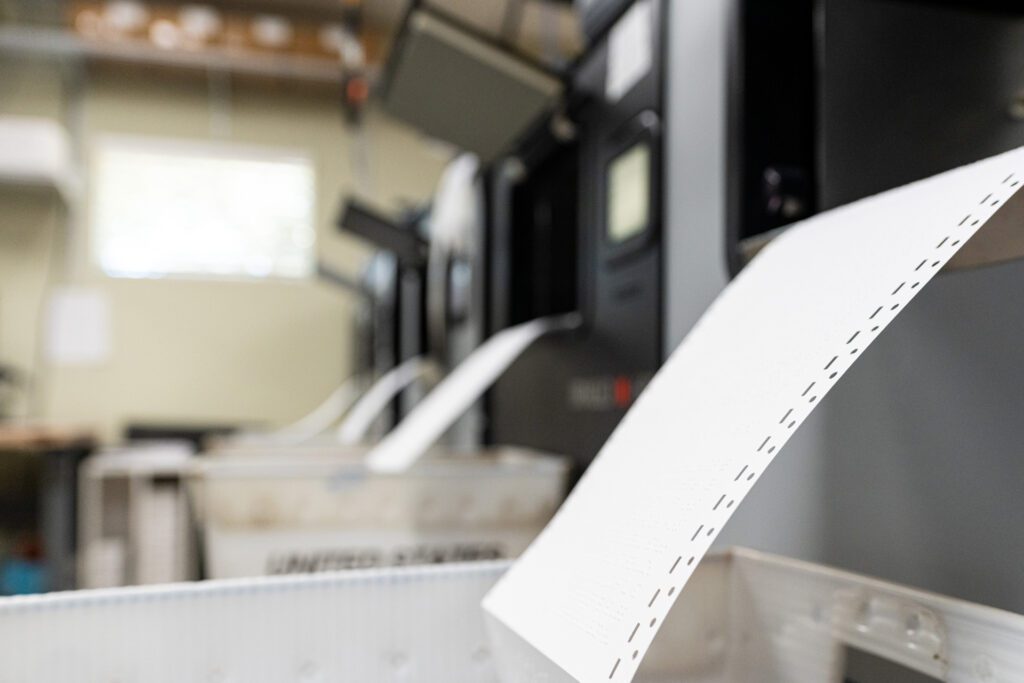 a row of printers with paper coming out