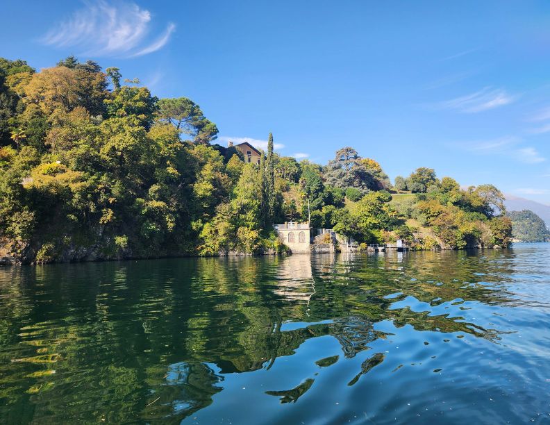 September 2027, Still lake water meeting a house and garden