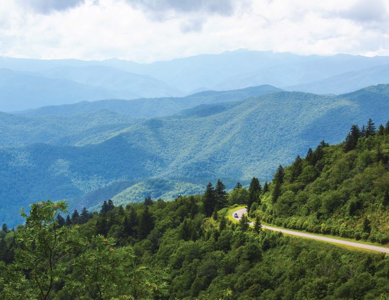 January 2028, Winding road through the mountains with a single car driving