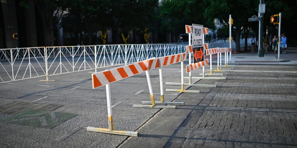 Roadblock barrier with signs saying "Road closed" and "Detour"